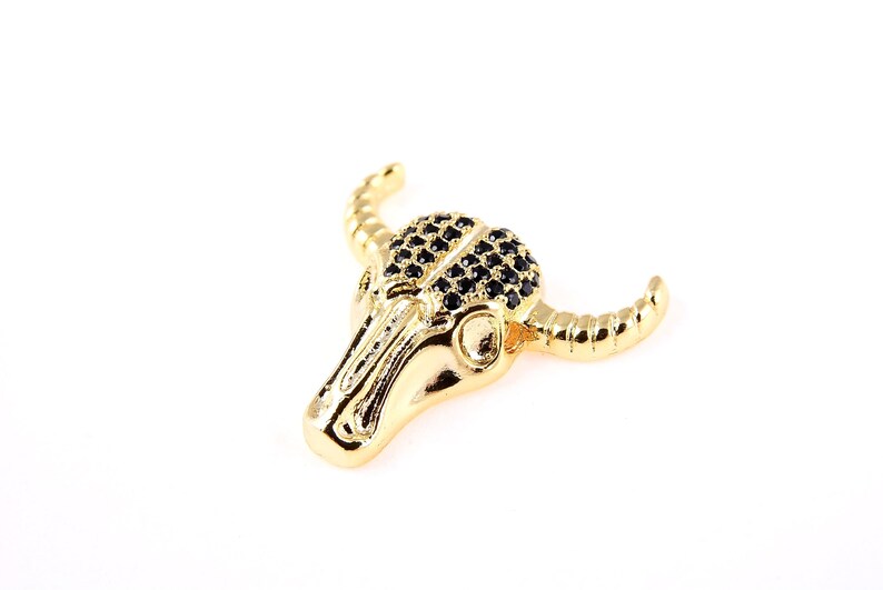 May include: Gold-tone bull skull pendant with black crystal accents.