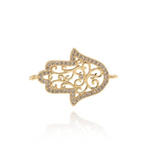 May include: Gold-toned hamsa hand charm with clear crystal embellishments. The hamsa hand is a popular symbol of protection and good luck.