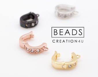 May include: Four different colored metal clasps with clear rhinestones. The clasps are in silver, gold, rose gold, and black.