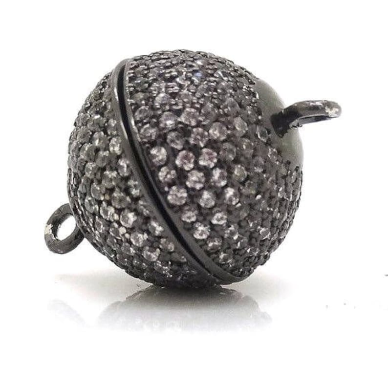 May include: Black metal ball clasp with a pave setting of small clear rhinestones. The clasp is designed to be used as a necklace or bracelet closure.
