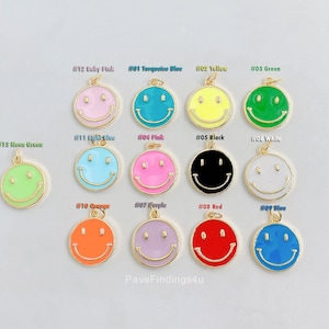 Op de afbeelding: Assortiment van 12 smiley-charms in verschillende kleuren, waaronder roze, blauw, geel, groen, lichtblauw, zwart, wit, oranje, paars, rood en blauw. De charms zijn gemaakt van goudkleurig metaal met emaille verf.
