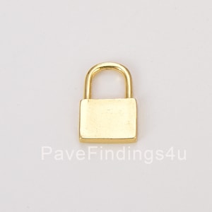May include: A small gold padlock charm. The padlock is closed and has a square shape.