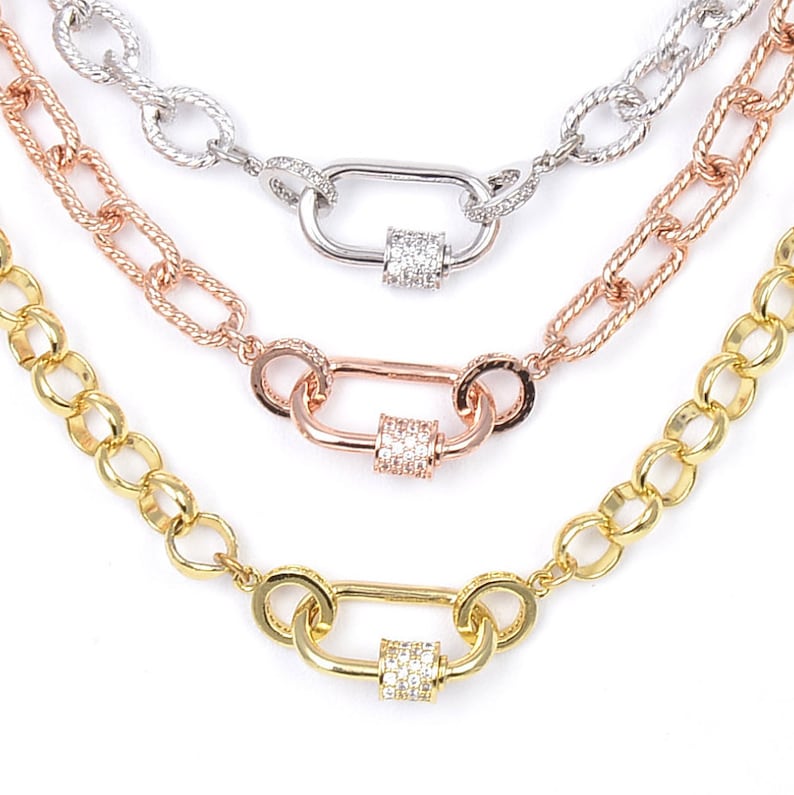 K&ouml;nnte beinhalten: Drei goldene Kettenhalsketten mit einem Diamant-Pav&eacute;-Verschluss. Die Ketten sind in verschiedenen Stilen gehalten, eine ist eine Curb-Kette, eine ist eine Seil-Kette und eine ist eine Box-Kette.