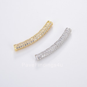 May include: Two curved connector pieces for jewelry making. One is gold and one is silver. Both are covered in small clear rhinestones.