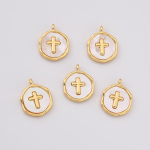 Op de afbeelding: Vijf gouden kruisbedels met witte parelmoer inleg. Elke bedel heeft een lus om aan een ketting of armband te bevestigen.