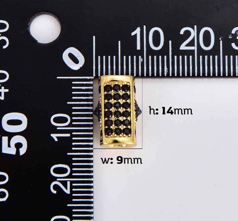 May include: Gold-toned spacer bead with black cubic zirconia stones. The bead is 14mm high and 9mm wide. h: 14mm w: 9mm
