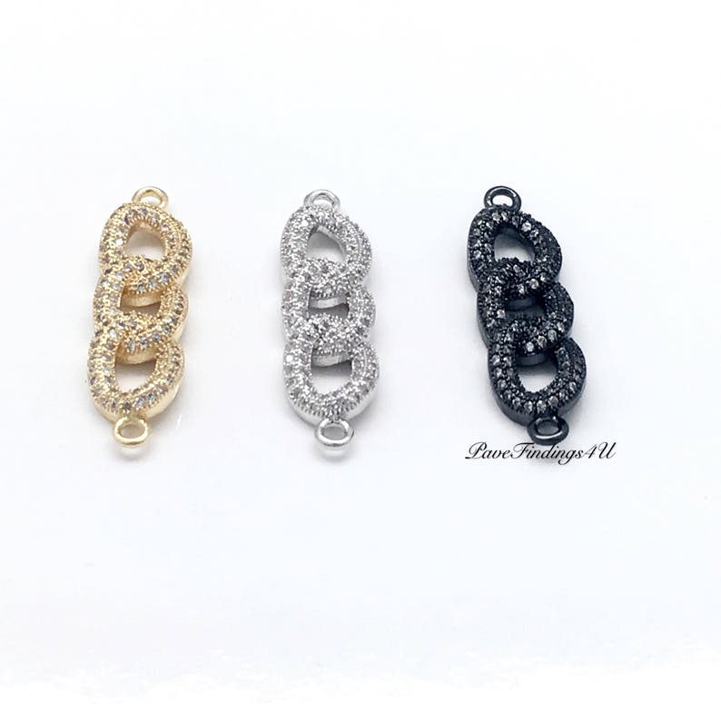 May include: Three chain link connectors in gold, silver, and black. Each connector features three interlocking links encrusted with small, clear gemstones. The connectors have small loops at each end for attaching to other jewelry components.
