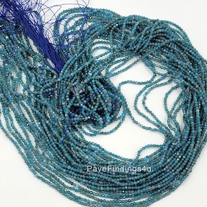 May include: A strand of teal blue gemstone beads, approximately 2 mm in size, with a faceted finish. The beads are strung on a blue thread and are ready for jewelry making.