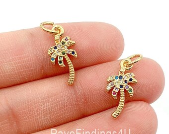 May include: Two gold palm tree charms with colorful crystal accents. The charms have a loop at the top for attaching to jewelry.
