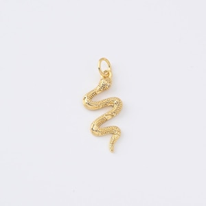 Peut inclure: Pendentif serpent doré avec un corps texturé et une petite boucle en haut pour l'accrocher. La tête du serpent a un petit accent clair. Le pendentif est conçu pour être porté comme bijou.
