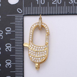 Pu&ograve; includere: Chiusura dorata con pietre di zircone cubico trasparenti. La chiusura &egrave; lunga circa 2 cm.