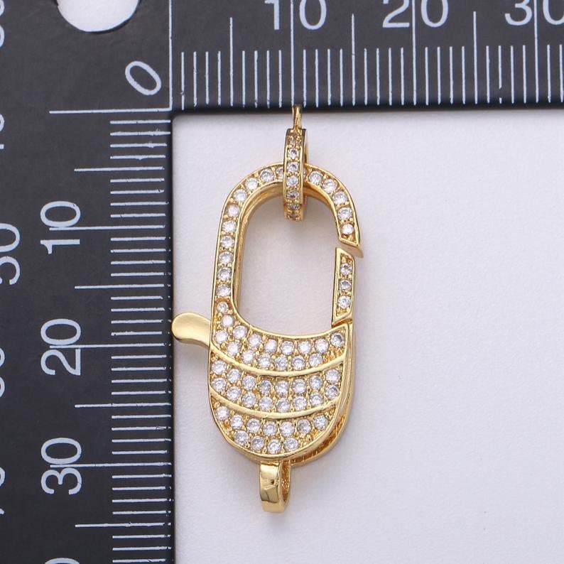 Pu&ograve; includere: Chiusura dorata con pietre di zircone cubico trasparenti. La chiusura &egrave; lunga circa 2 cm.