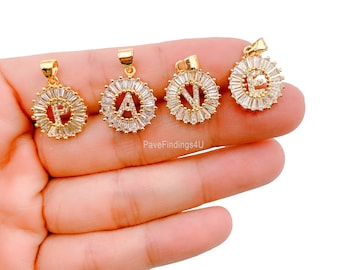 May include: Four gold-tone pendants with clear cubic zirconia stones arranged in a circle around a letter. The letters are P, A, N, and E.