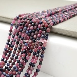 May include: A strand of faceted gemstone beads in shades of blue, pink, and purple. The beads are approximately 4mm in size and are strung on a clear thread.