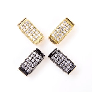 May include: Four rectangular jewelry connectors with a pave setting of clear cubic zirconia stones. Two connectors are gold-toned and two are black.