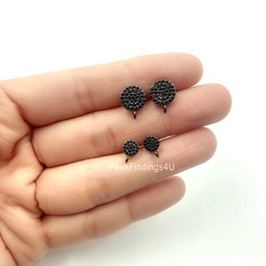 May include: Three pairs of black, round, pave-set earring findings. The findings are in different sizes. The largest pair is at the top, the smallest pair is at the bottom, and the middle pair is in between.