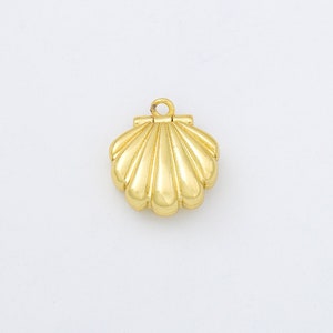 May include: A gold-colored seashell charm with a hinged opening. The charm is designed to be used as a pendant or a decorative element.