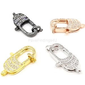 Pu&ograve; includere: Quattro chiusure a moschettone di diversi colori con pav&eacute; di cristallo trasparente. Le chiusure sono in nero, oro rosa, oro e argento.