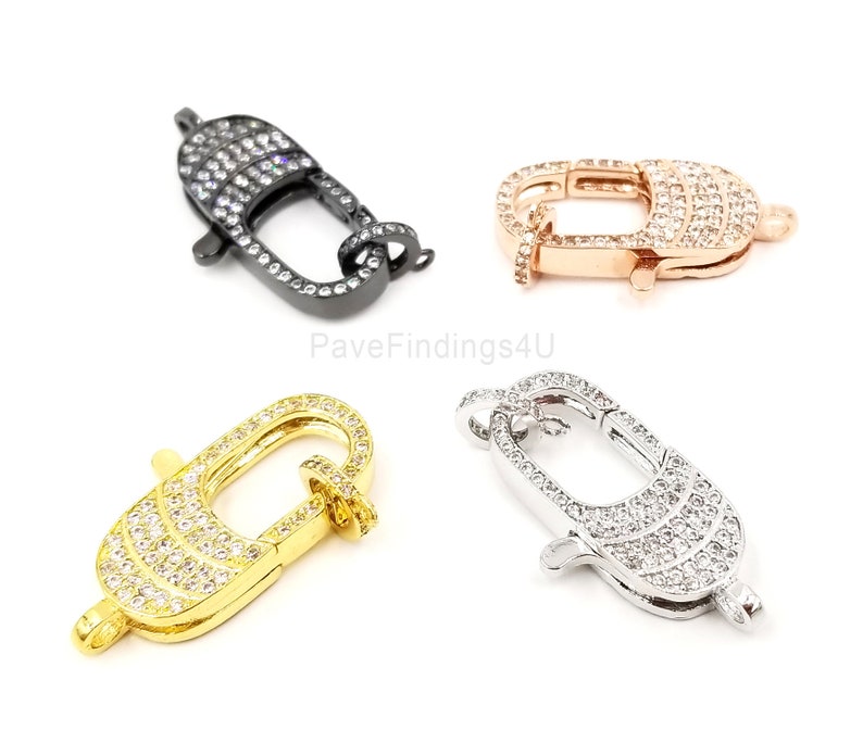 Pu&ograve; includere: Quattro chiusure a moschettone di diversi colori con pav&eacute; di cristallo trasparente. Le chiusure sono in nero, oro rosa, oro e argento.