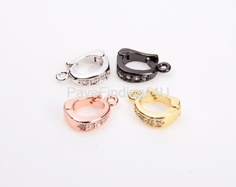 May include: Four different colored metal clasps with clear crystal accents. The clasps are silver, black, rose gold, and gold.
