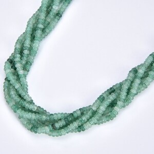 May include: A strand of green gemstone beads, with a frosted finish, strung together to form a necklace.
