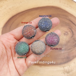 May include: Five round, silver-toned, pave-set, gemstone beads. The beads are in the colors of sapphire, orange, fuchsia, green, and champagne.