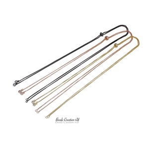 May include: Three different chain styles for jewelry making. The chains are black, gold, and rose gold. Each chain has a small clear crystal at the end.