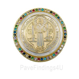 May include: A gold-toned medallion with a religious figure at the center, surrounded by text and colorful gemstones. The medallion has a white and gold border. The image includes the text "PaveFindings4U".