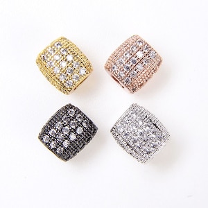 Pode incluir: Quatro espaçadores de contas de forma quadrada com um engaste pavé de strass transparentes. Os espaçadores estão disponíveis em ouro, ouro rosa, preto e prata.