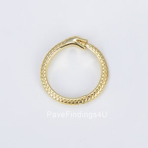 Può includere: Anello in oro con un design a forma di serpente. Il serpente si morde la coda, formando un cerchio. Il serpente è testurizzato e ha un design a forma di mano nella parte superiore.