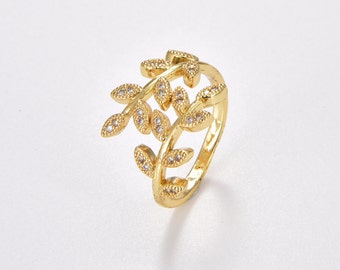 May include: Gold ring with a delicate design of intertwined branches adorned with small clear stones.