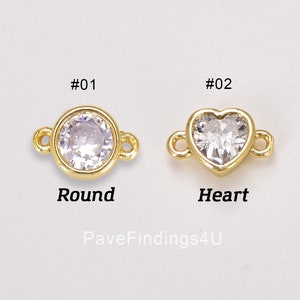 Puede incluir: Dos abalorios conectores de tono dorado con piedras de cristal transparentes. El abalorio de la izquierda es redondo y el de la derecha tiene forma de corazón. Los abalorios están etiquetados como #01 Redondo y #02 Corazón.