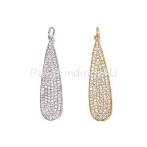 May include: Two teardrop-shaped pendants with a pave setting of clear cubic zirconia stones. The pendants are available in silver and gold.