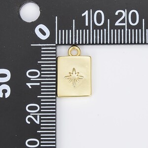 May include: Gold-toned charm with a star design. The charm is square shaped and measures approximately 1 cm in width.