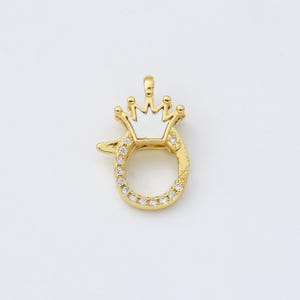 May include: Gold-tone clasp with a white enamel crown and clear crystal accents.