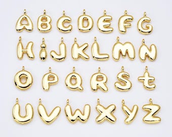 May include: Gold-colored alphabet letter charms, each letter is a separate charm. The letters are in a bubble-like font style.