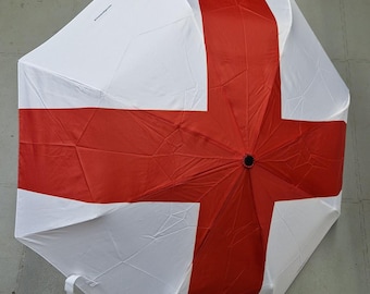 Paraguas de viaje plegable St George Cross con mecanismo de apertura y cierre automático con botón pulsador, asa y correa de fácil agarre.