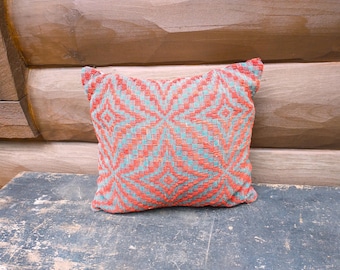 Cojín antiguo de colcha roja y gris, pequeño detalle para silla rústica de estilo granja.