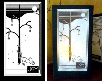 May include: Black and white illustration of a cat under a tree with ornaments. The tree is in a snowy landscape with a moon in the sky. The text "JOY" is at the bottom of the image.
