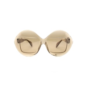 May include: A pair of brown oval-shaped sunglasses with a clear frame.