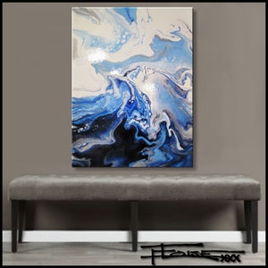 May include: Abstract painting with swirling blue, white, and black paint. The painting is on a canvas and is hanging on a gray wall above a gray bench.