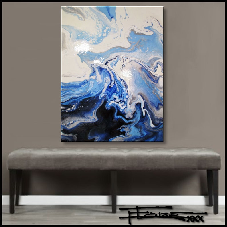 May include: Abstract painting with swirling blue, white, and black paint. The painting is on a canvas and is hanging on a gray wall above a gray bench.