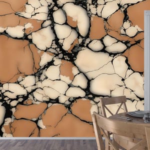 K&ouml;nnte beinhalten: Ein Wandbild mit einem gro&szlig;fl&auml;chigen, abstrakten Muster aus unregelm&auml;&szlig;igen, rissigen Formen in warmen Terrakotta-Orange- und cremefarbenen T&ouml;nen, die durch kr&auml;ftige, schwarze Adern getrennt sind und einen kontrastreichen Steineffekt erzeugen.