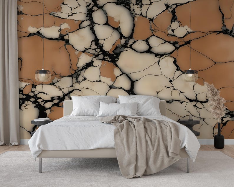 K&ouml;nnte beinhalten: Ein Schlafzimmer mit einem Bett mit wei&szlig;er Bettw&auml;sche und einer beigen Tagesdecke, das vor einer Wand mit einer Tapete mit gro&szlig;fl&auml;chigem, rissigem Steinmuster in Beige-, Creme- und Schwarzt&ouml;nen steht, flankiert von zwei h&auml;ngenden Pendelleuchten.