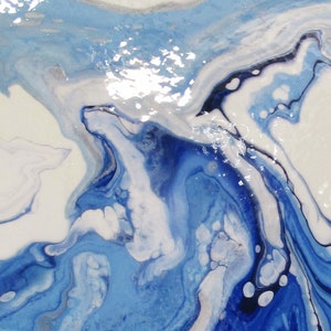 May include: Abstract painting with swirling blue, white, and black paint. The paint has a glossy finish.