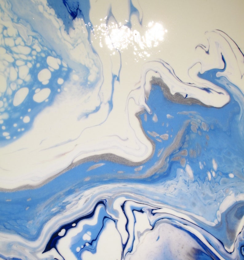 May include: Abstract painting with swirling blue, white, and silver paint. The colors blend together to create a marbled effect.