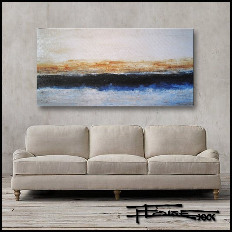 May include: Abstract painting on canvas with a horizontal band of blue, black, and orange. The painting is displayed on a wall above a beige sofa.