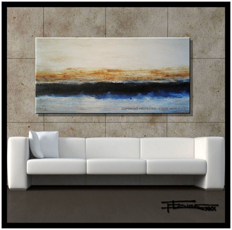 May include: Abstract painting with a horizontal band of blue, black, and brown across the middle of the canvas. The background is a light beige color. The painting is hanging on a wall above a white sofa.