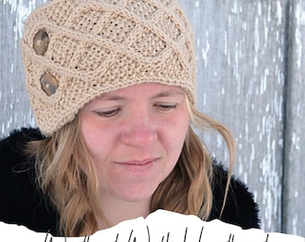 Könnte beinhalten: Ein beiger Strickkopfband mit einem Zopfmuster und zwei braunen Knöpfen. Das Kopfband wird von einer Person mit blonden Haaren getragen. Der Text "A Woodland Walk Headband knitting pattern" ist in Weiß auf grauem Hintergrund geschrieben.
