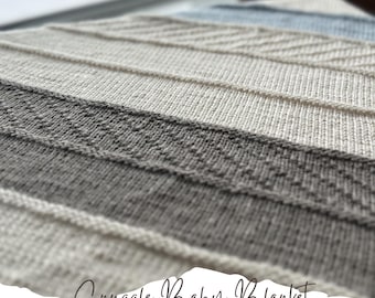 May include: A close-up of a knitted baby blanket with stripes of white, gray, and blue yarn. The blanket has a simple stitch pattern and is soft and cozy. The text "Snuggle Baby Blanket knitting pattern" is written on the bottom of the image.